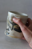 White and black painted wobble cup