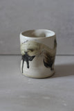 White and black painted wobble cup